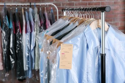 Rack of clean clothes hanging on hangers at dry-cleaning | Supreme Dry ...